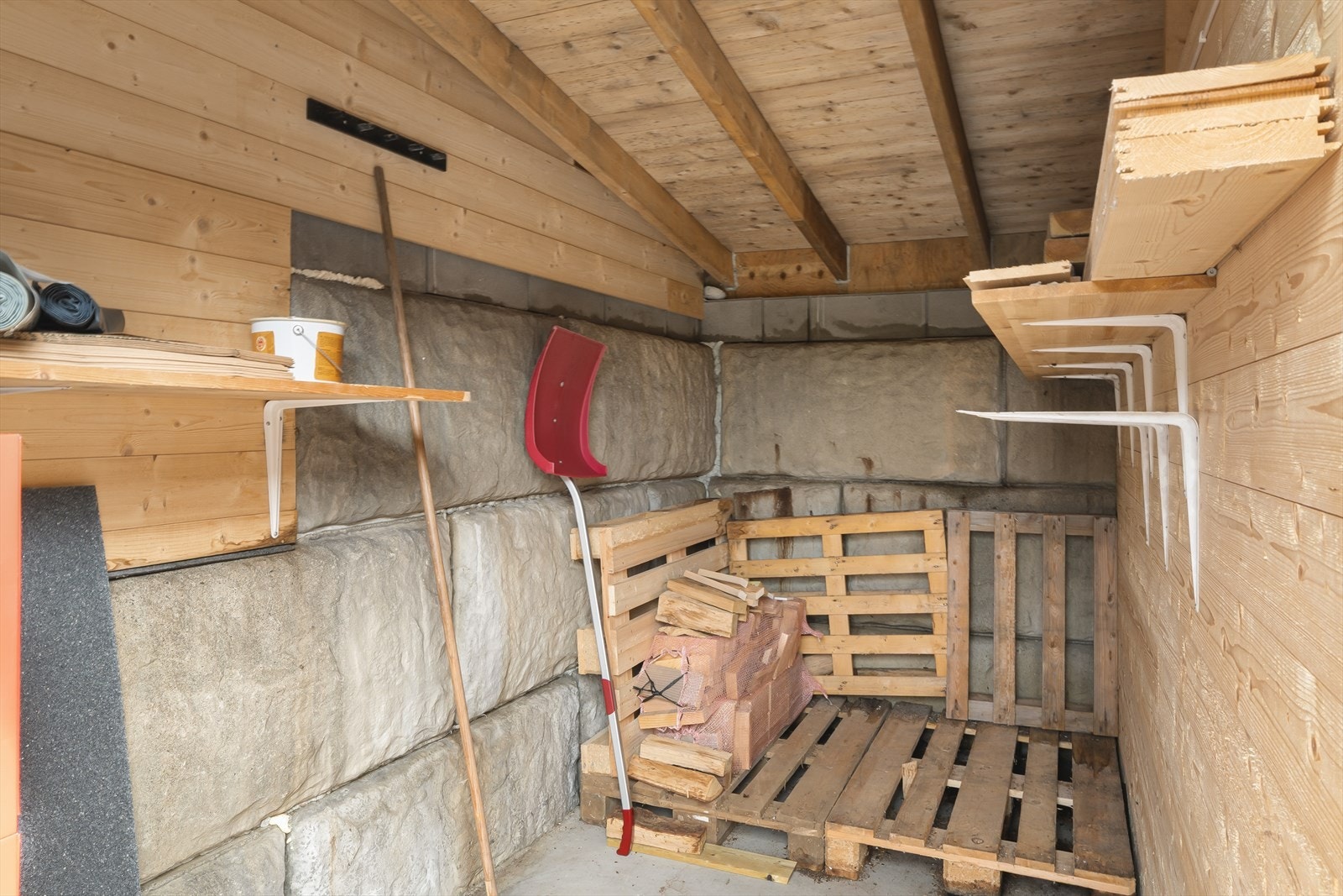Innvendig bod i carporten med panelkledde vegger og god plass til oppbevaring. Galleribilde