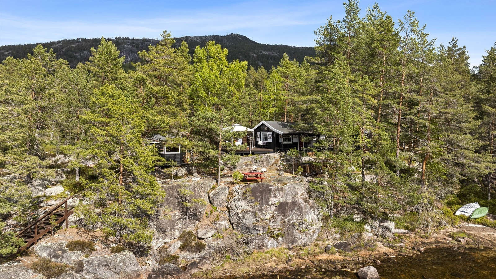 Denne fritidsboligen ligger usjenert til på en egen odde ved Nisser, omgitt av en kupert naturtomt.
Foto: Fotograf Magik Galleribilde