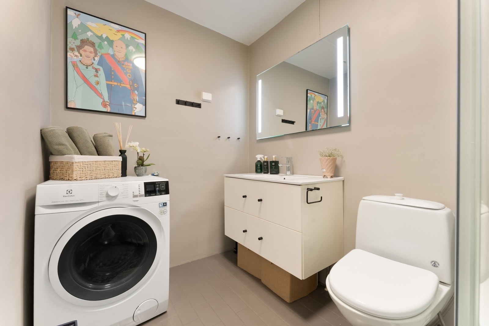 Badet er innredet med vegghengt toalett, dusjkabinett, servantinnredning med skuffer og speil. Galleribilde