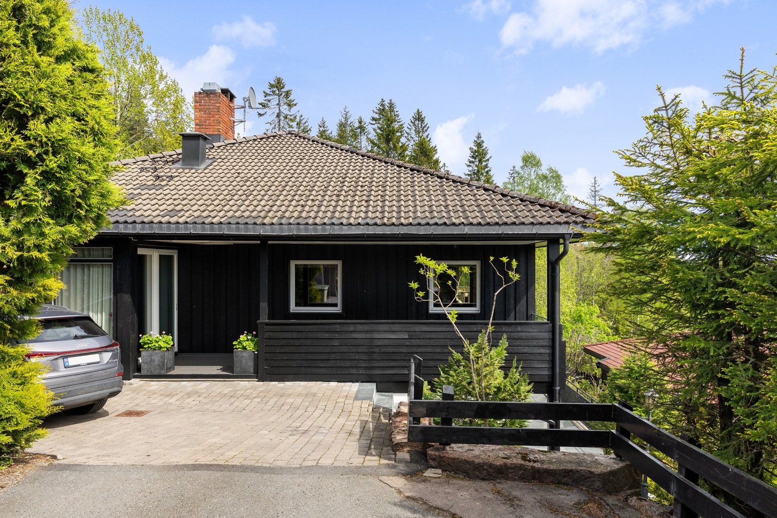 Eiendommen har gode parkeringsmuligheter med to biloppstillingsplasser på egen tomt ved siden av huset, utstyrt med elbillader på vegg. Galleribilde