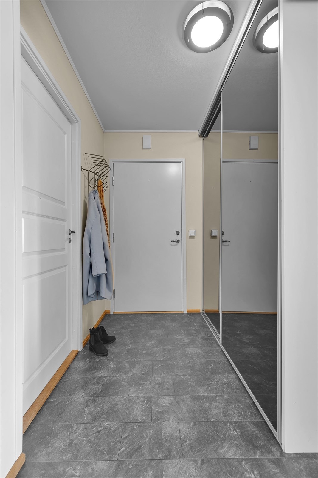 Entreen er innredet med en romslig og meget praktisk skyvedørsgarderobe for oppheng og lagring av yttertøy. Galleribilde