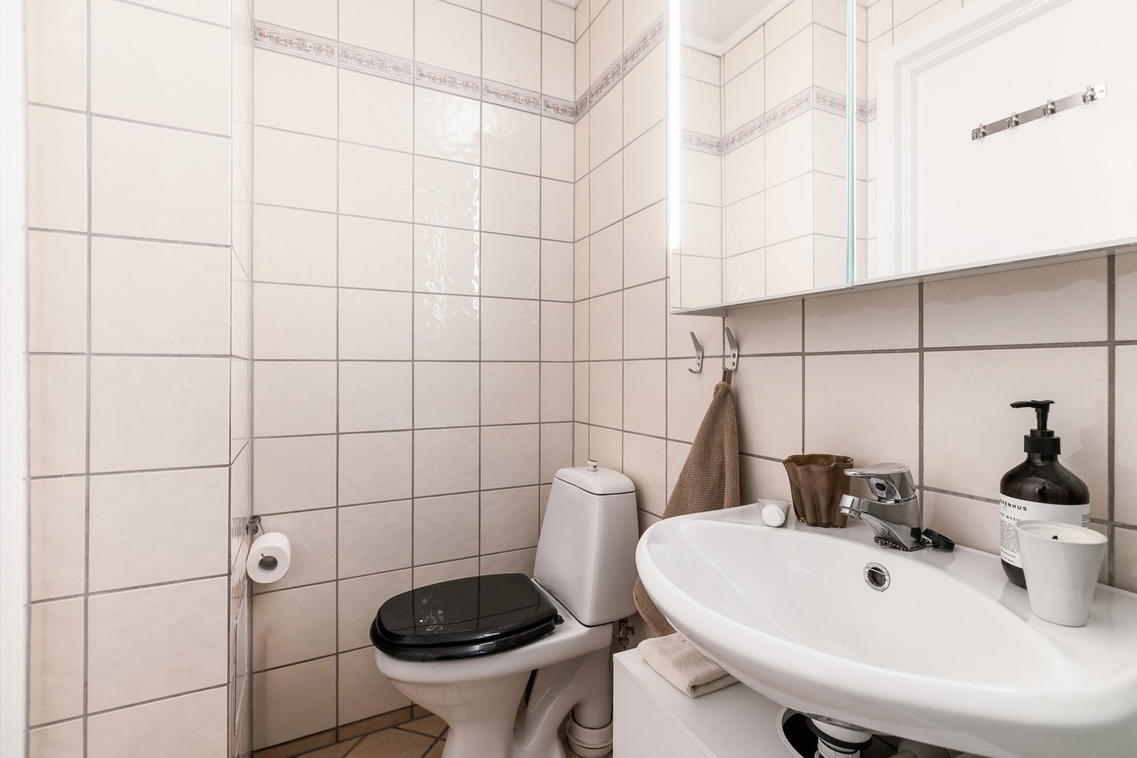 Badet har gulvmontert klosett, dusjkabinett og baderomsinnredning med servant. Galleribilde