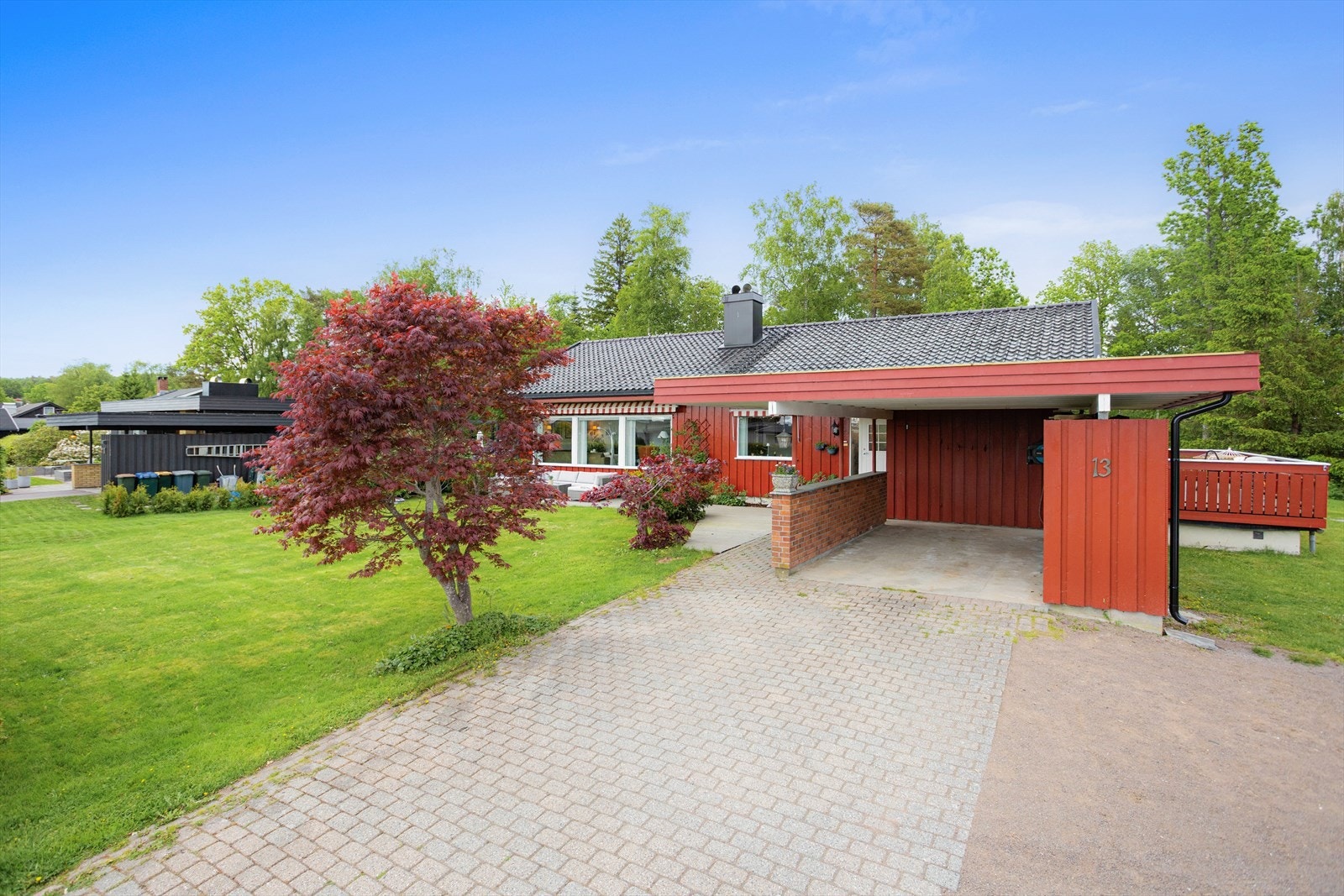 Steinsatt innkjørsel fører til carport og det er gruslagt foran den doble garasjen. Ellers gode parkeringsmuligheter på egen tomt. Galleribilde