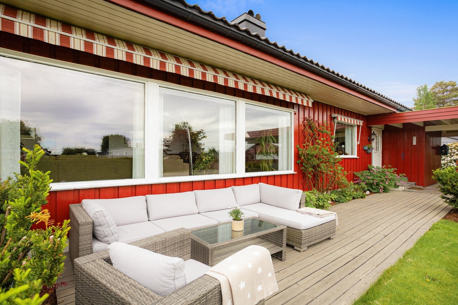Terrassen foran boligen er et hyggelig sted for en sittegruppe. Her er det elektrisk markise. Galleribilde