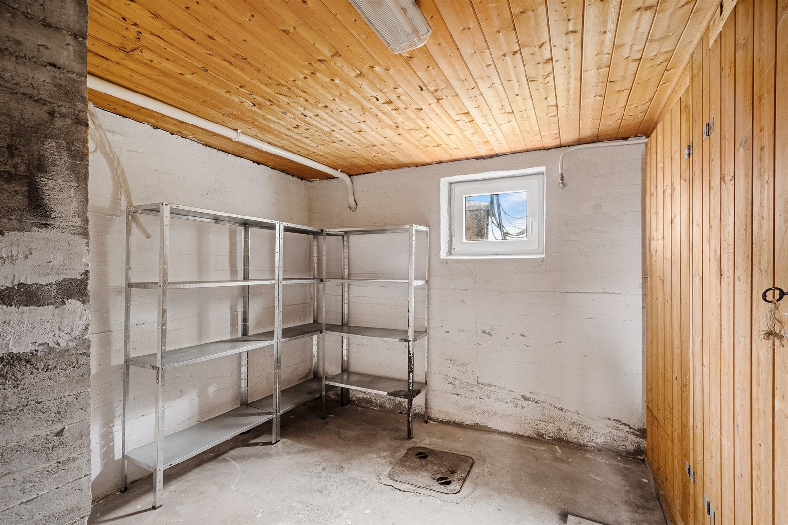 Kjelleren har betonggulv og synlig grunnmur. Her er også en sentralstøvsuger fra byggeåret plassert. Vi kjenner ikke til hvorvidt denne fungerer. Galleribilde