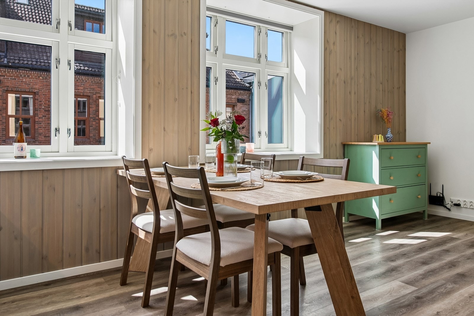 Spiseplassen er naturlig plassert ved vinduene. Legg merke til kombinasjonen av malte flater og panel på veggene. Galleribilde