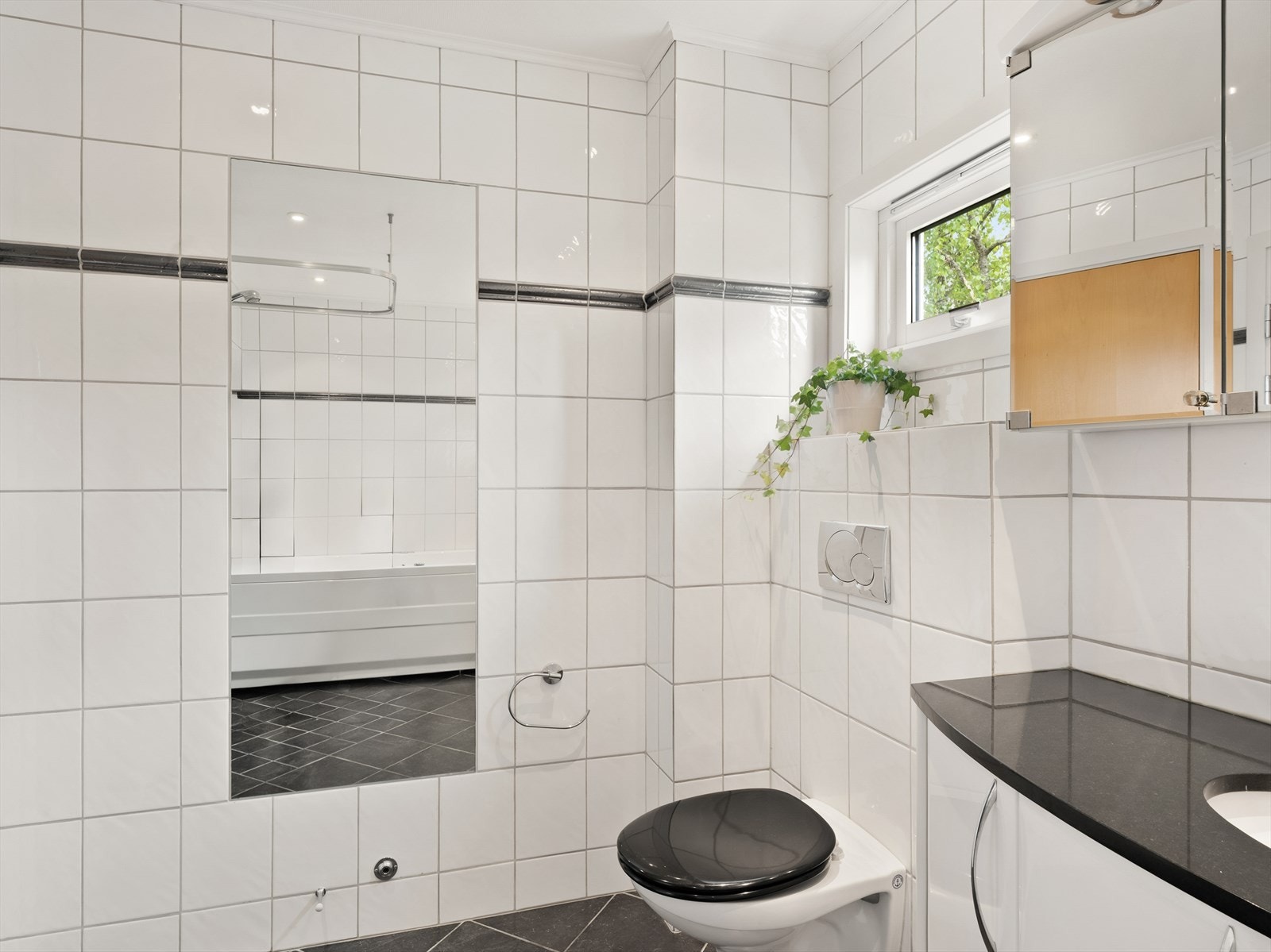 Badet i første etasje er fra 2004, med flislagt gulv og vegger. Galleribilde