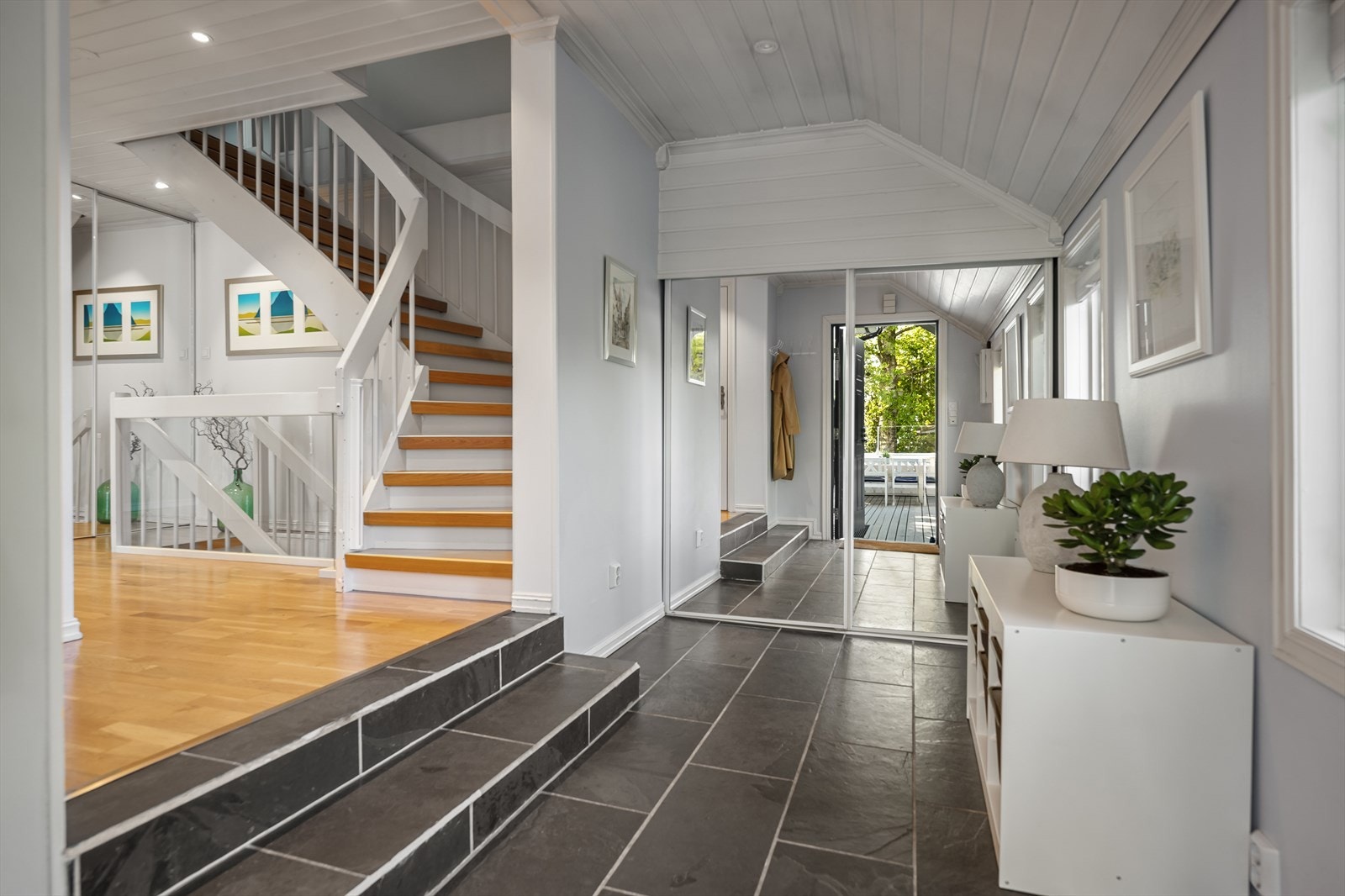 En romslig skyvedørsgarderobe med speilfronter gir rikelig med oppbevaringsplass i entréen. Galleribilde