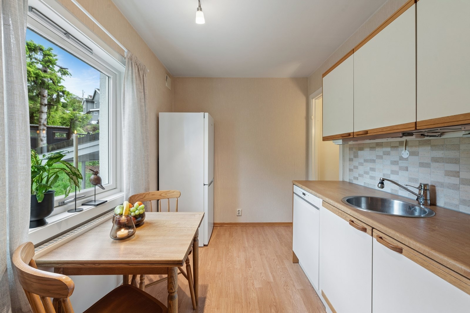 Innredningen har malte glatte fronter og laminat benkeplate med oppvaskkum av stål. Galleribilde
