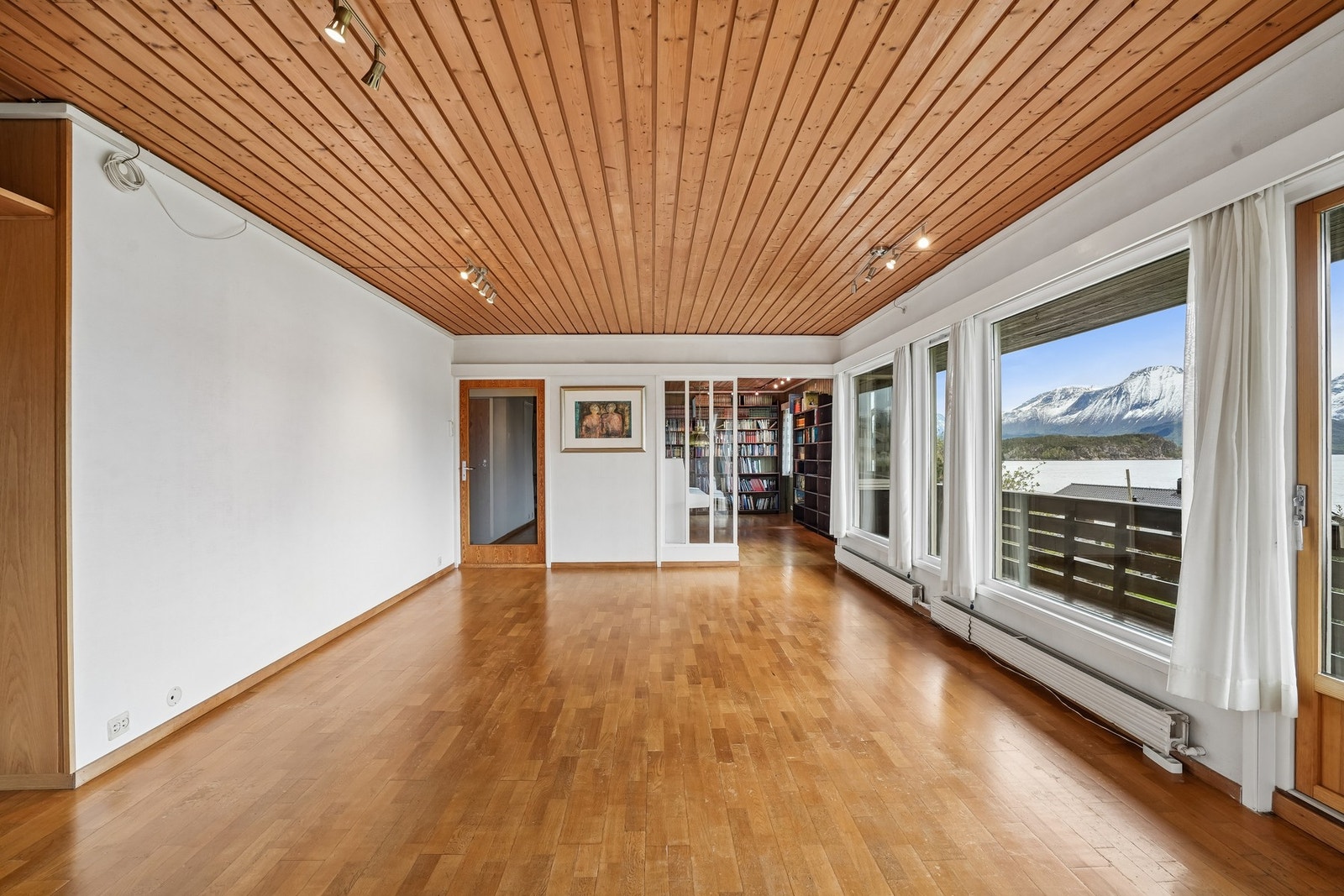 Det er parkett på gulvet, på veggene er det strie og i himling er det panel. Galleribilde