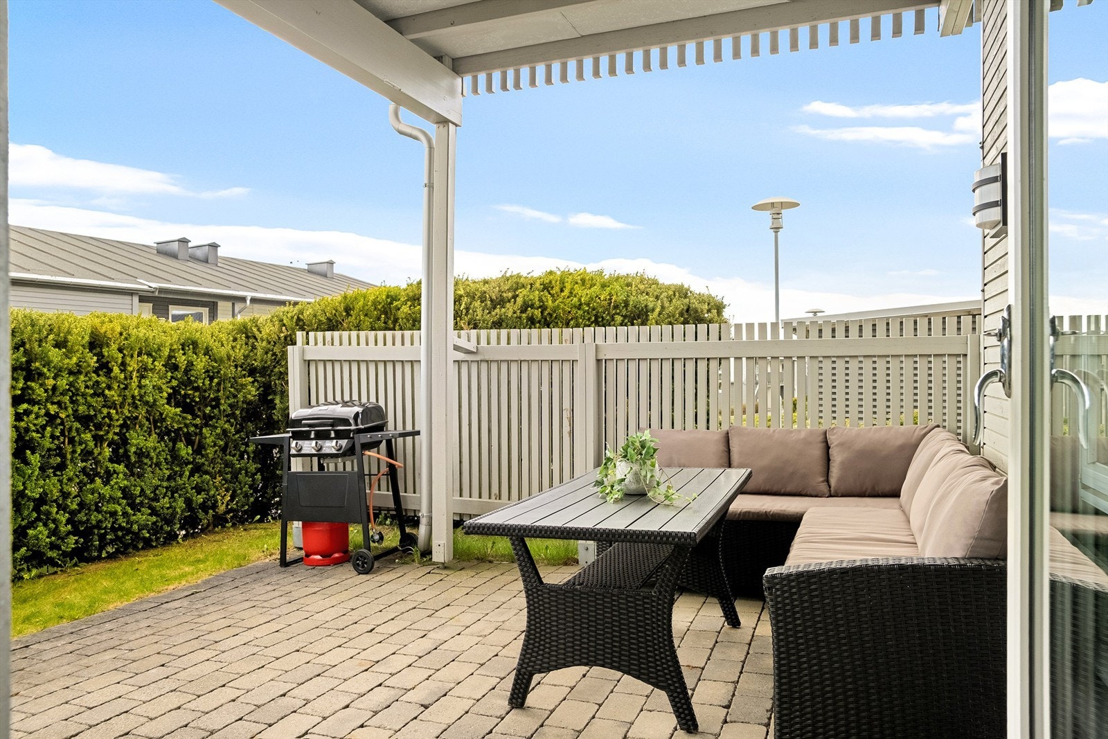 Tett overbygg gjør det mulig å sitte ute også om sommerværet ikke er på sitt aller beste. Hekken foran begrenser i tillegg vind. Galleribilde