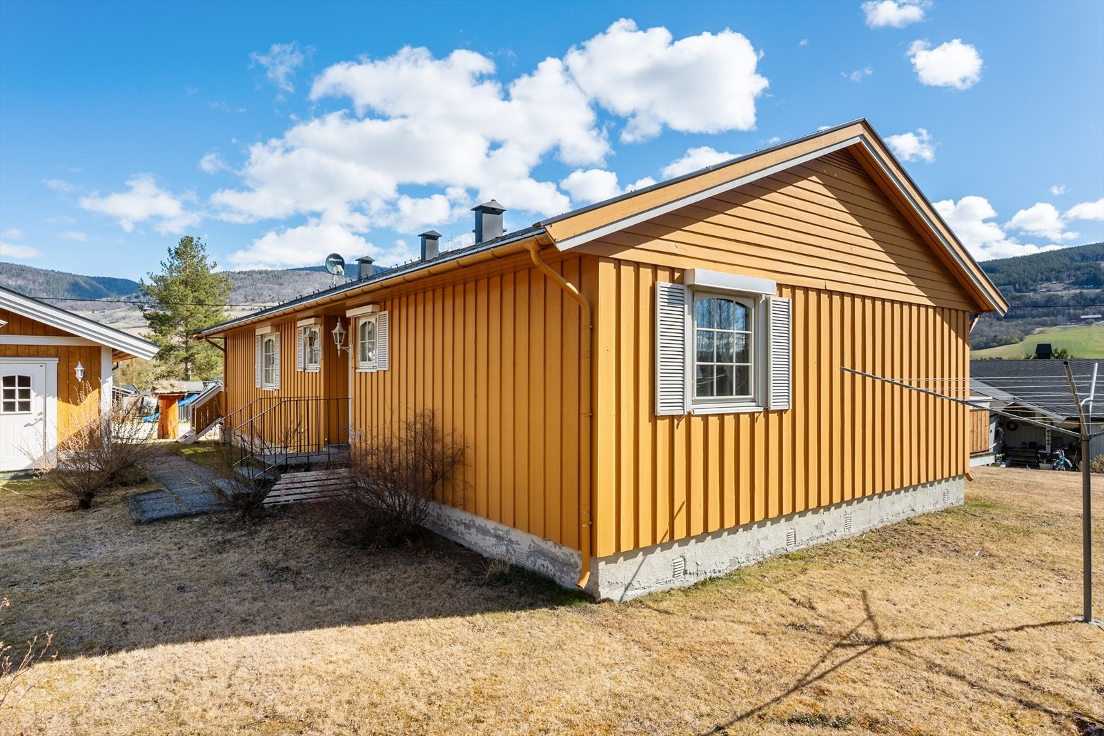 Tomten er opparbeidet med plen, brydpusker og noen trær. Galleribilde