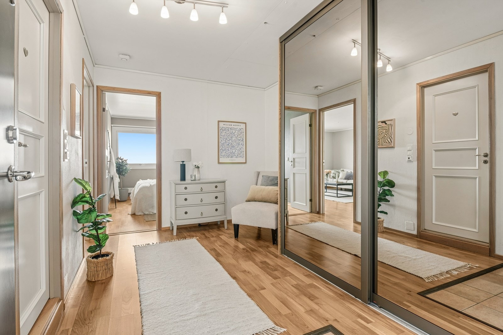 Entré med flislagt parti ved inngangsdøren og en romslig skyvedørsgarderobe for oppbevaring. Galleribilde