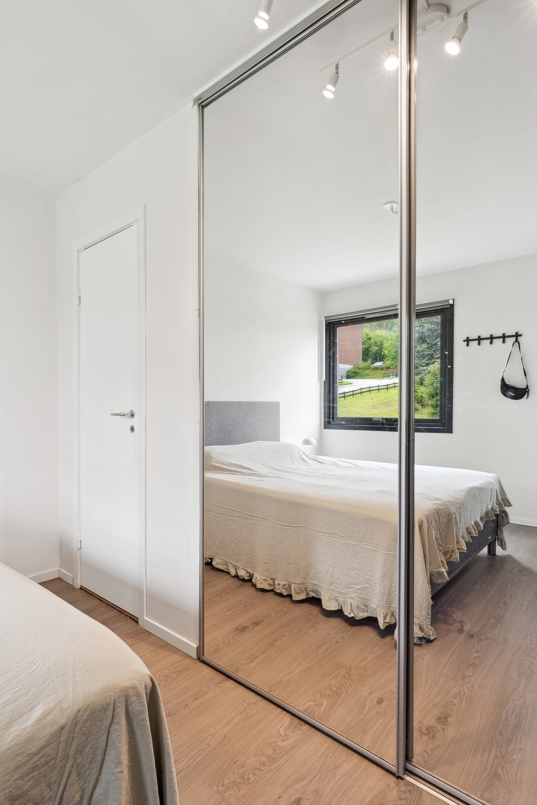 En romslig skyvedørsgarderobe med speilfronter gir rikelig med oppbevaringsplass. Galleribilde