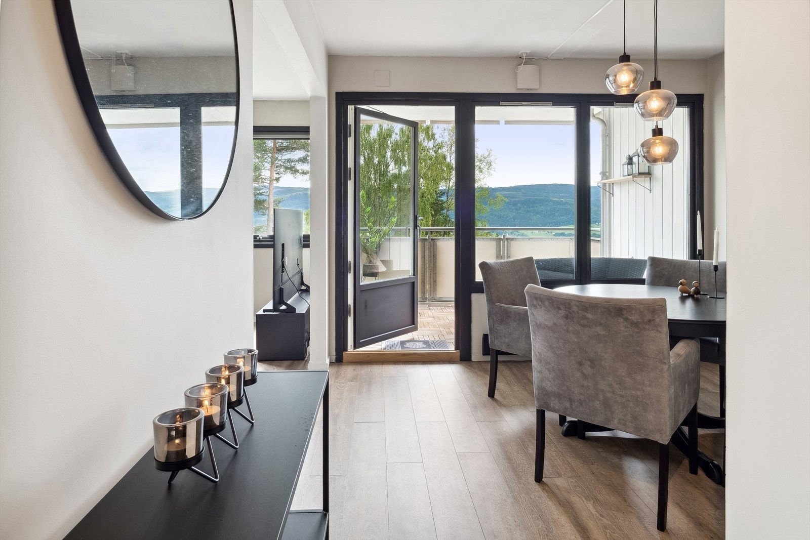Stuen har en stemningsfull vedovn og en åpen løsning mot spisestuen, med direkte utgang til balkongen. Galleribilde