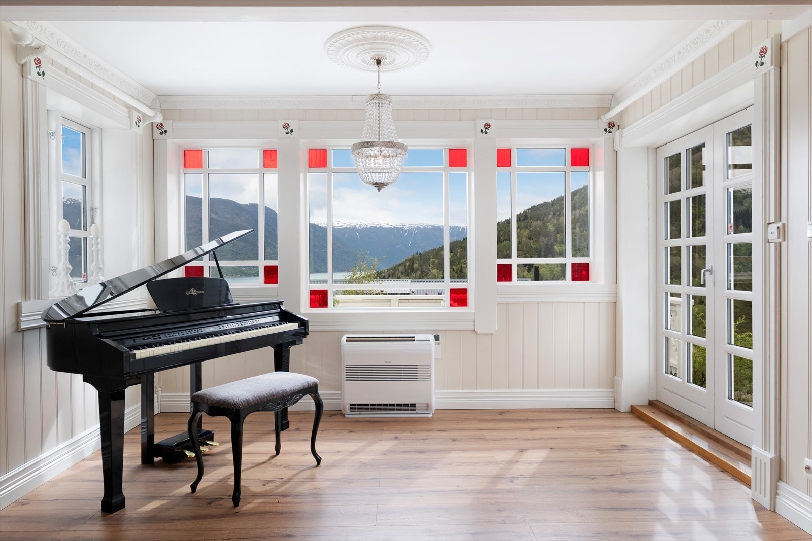 Det er store vindaugsflater i rommet som slepp inn godt med dagslys og ein får flott utsyn mot bygda og fjorden. Galleribilde
