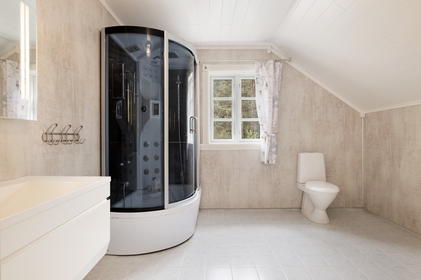 Badet i 2. etg er av god storleik med nedfeltservant med underskuffer, spegel med lyslist, dusjkabinett og toalett. Galleribilde