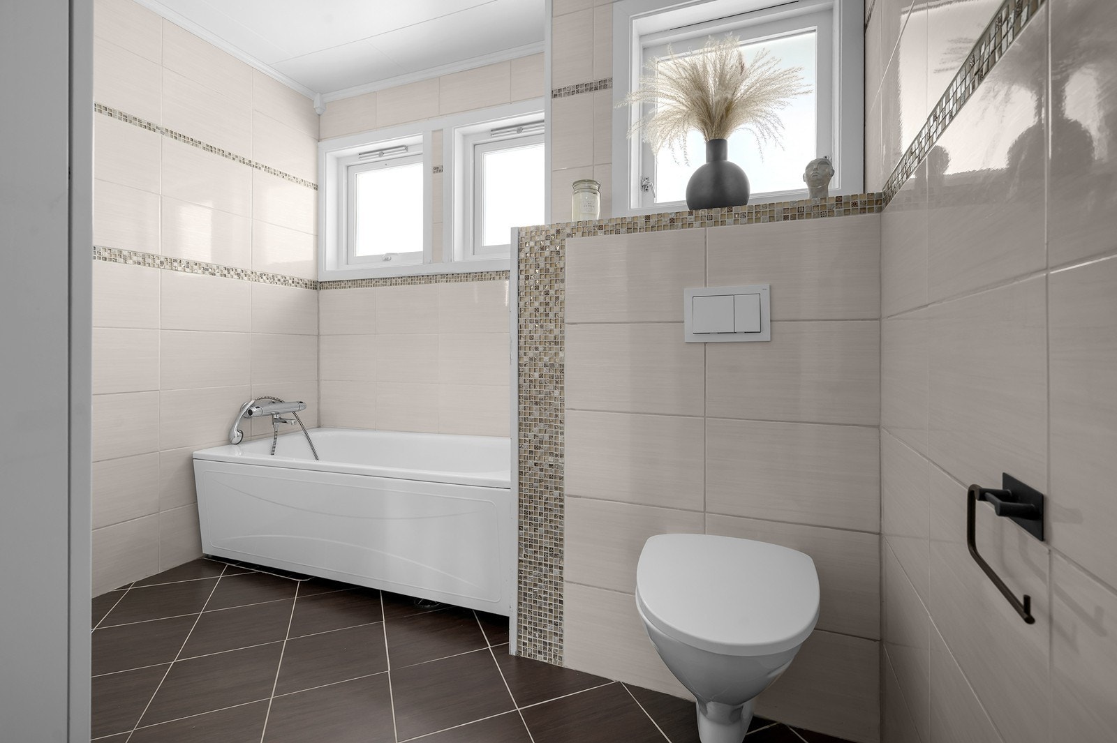 Moderne med vegghengt wc og mosaikkfliser som detaljer Galleribilde