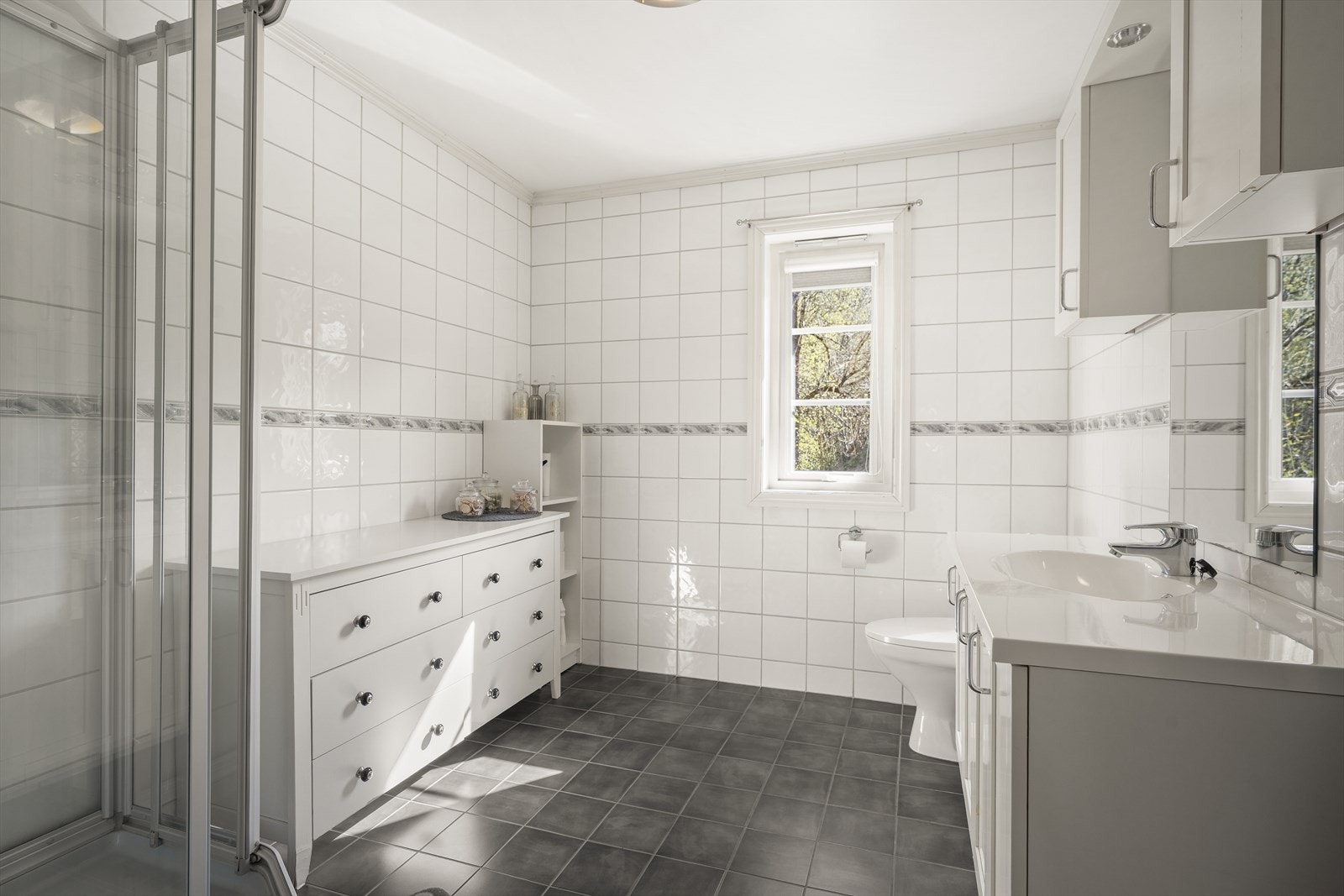 Badet er romslig med flislagte overflater og har elektriske varmekabler i gulvet. Galleribilde