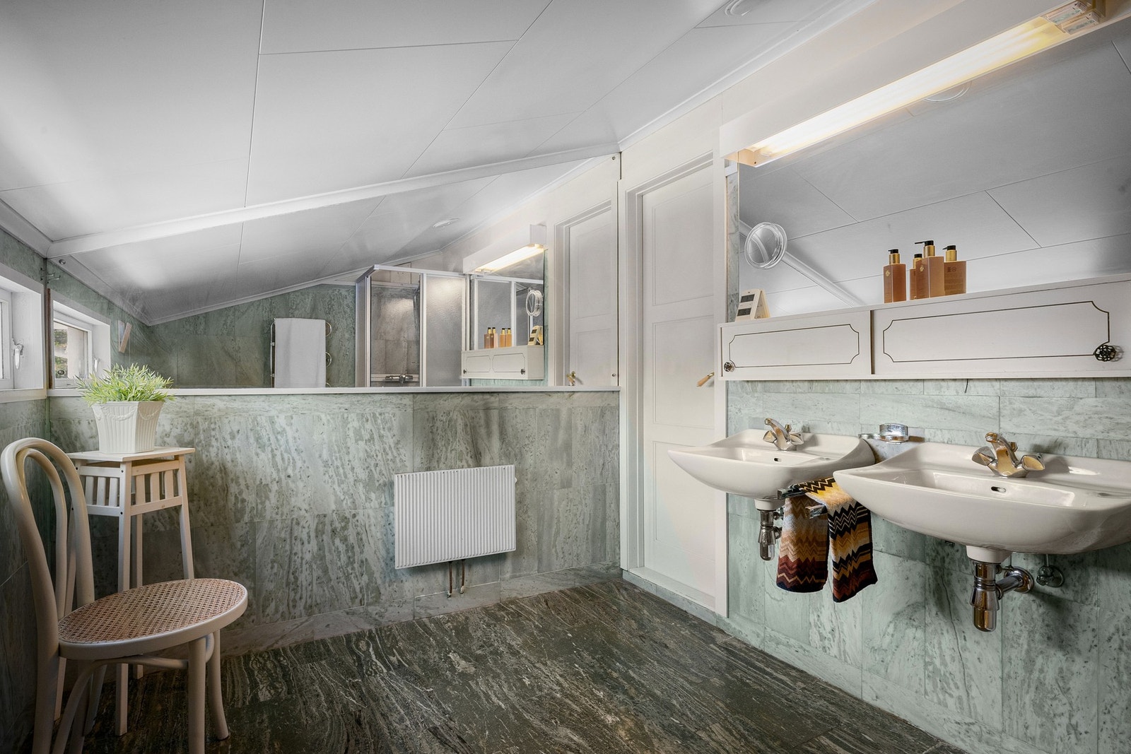 Badet er innredet med toalett, bidé, dobbel servant og dusjkabinett. Galleribilde
