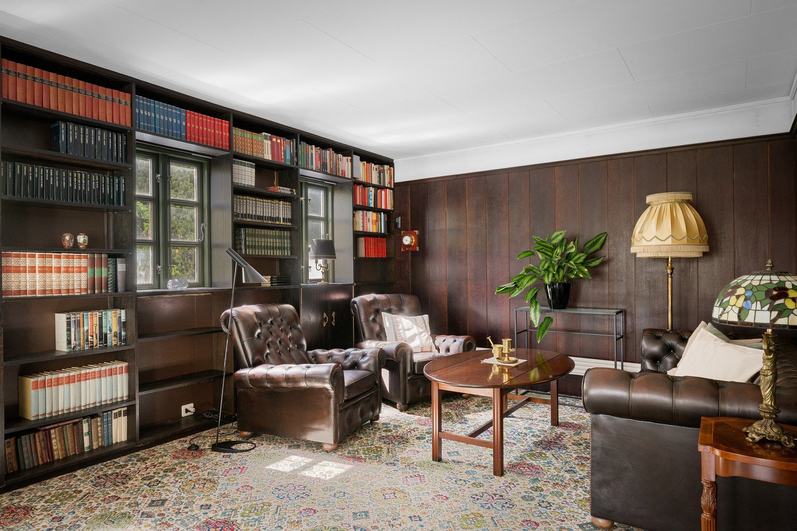 Karakterfull peisestue/bibliotek med elegante detaljer og gasspeis Galleribilde