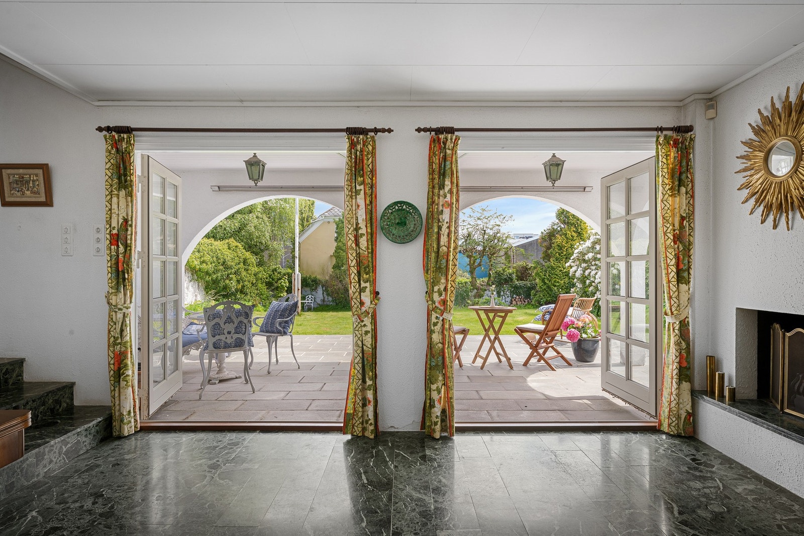 Fra peisestuen er det to franske dører som åpner opp mot en stor terrasse og videre ut til den flotte hagen Galleribilde