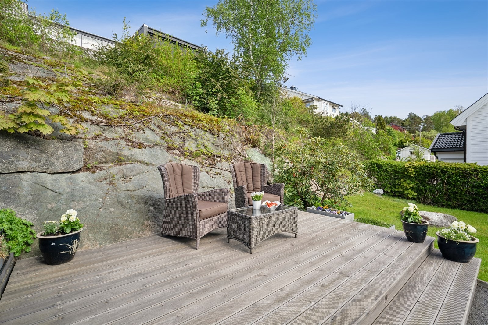 Eiendommen har flere fine uteplasser og en hage med både plen og fjell. Galleribilde