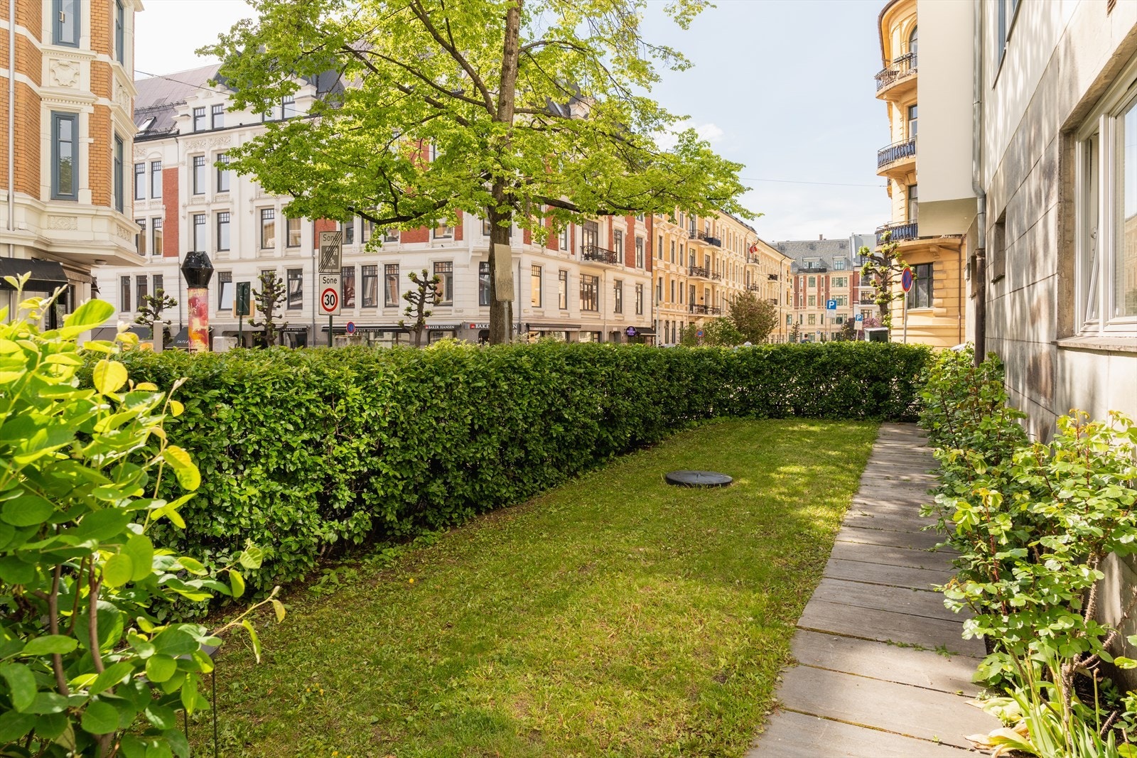 Pent opparbeidet forhage som skjermer mot gaten. Galleribilde