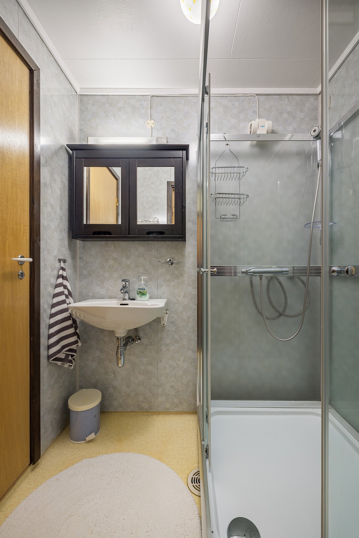 Badet er innredet med enkel servant og dusjkabinett. Galleribilde