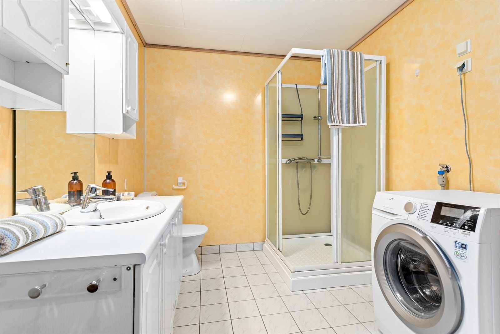 Badet er innreia med toalett, dusjkabinett og baderomsmøbel med heildekkande servant og underskåp. Galleribilde
