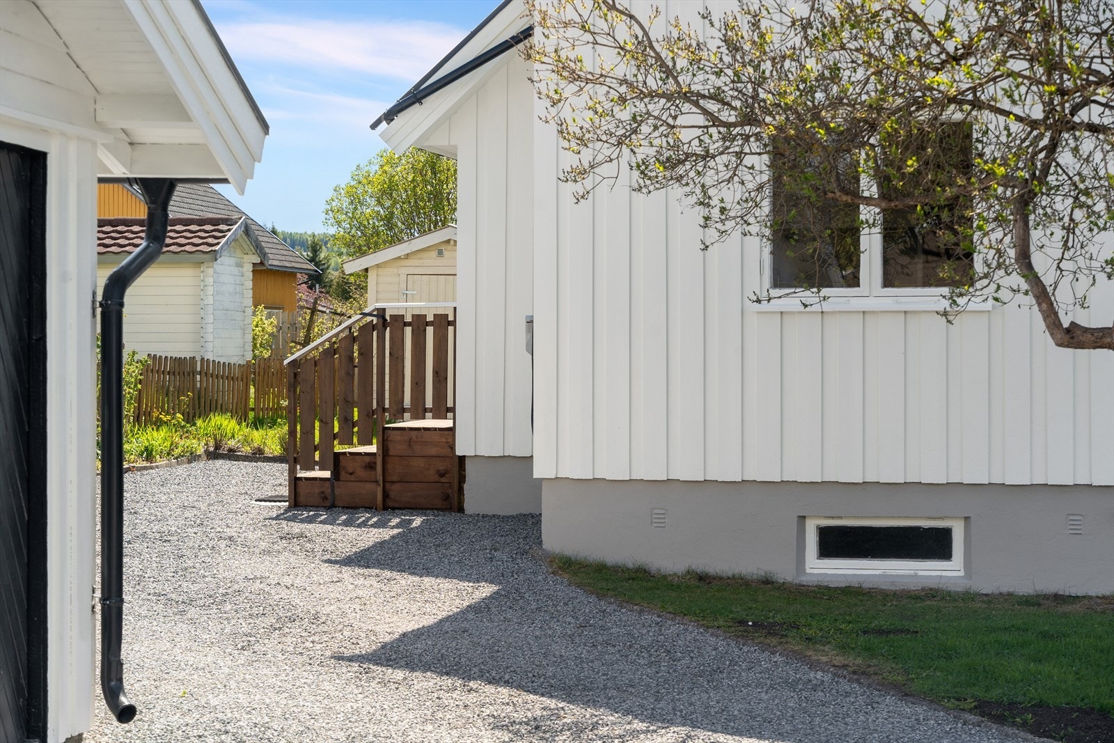Tomten er opparbeidet med plen og variert beplantning. Galleribilde