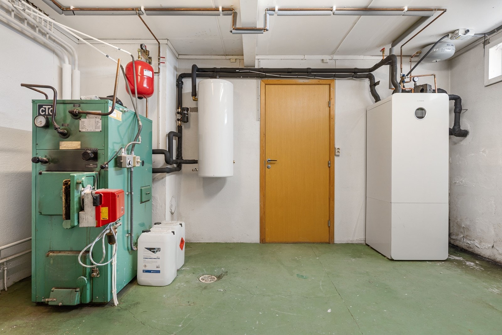 Teknisk rom i underetasje med nytt og gammelt fyringssytem. Galleribilde
