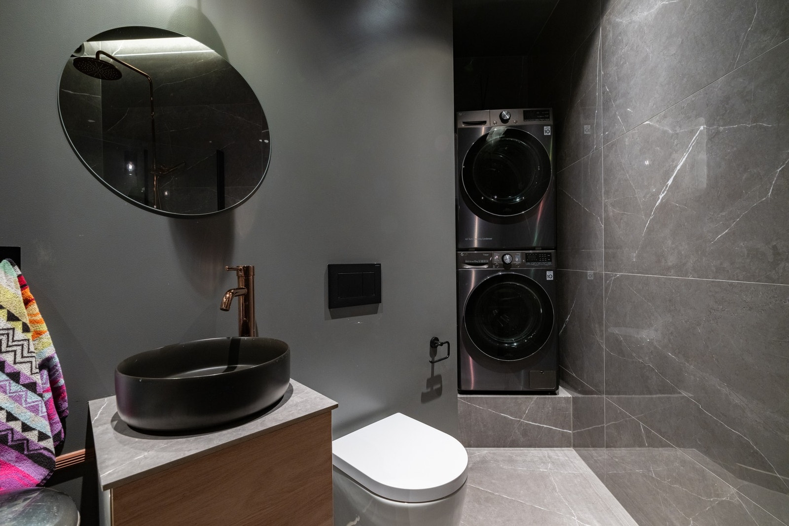 Videre er badet utstyrt med dusjhjørne med regnfallsdusj, vegghengt toalett samt opplegg for vaskemaskin og tørketrommel. Galleribilde