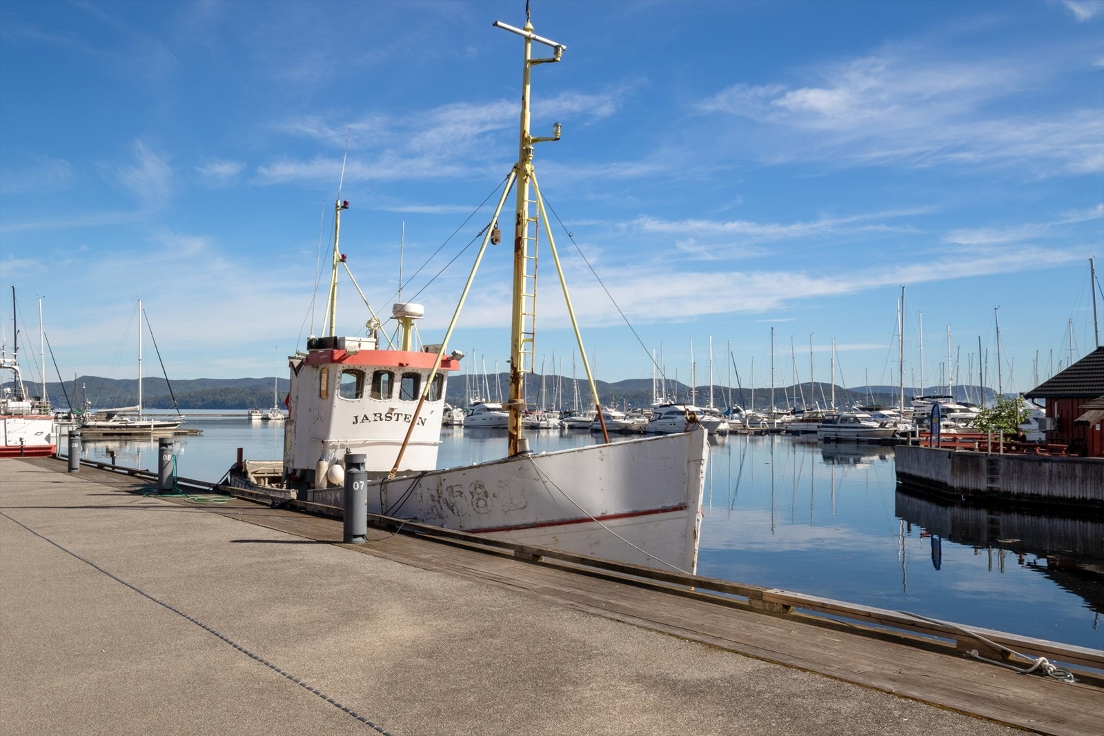 Her lever du tett på sjølivet, med båter og bryggeliv som en naturlig del av omgivelsene. Galleribilde