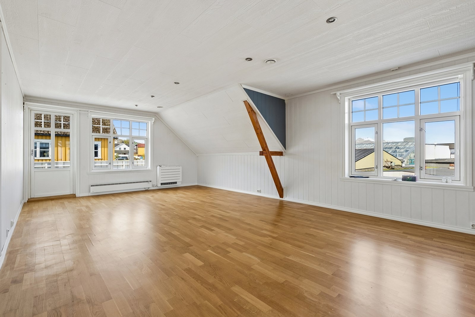 Rommet har lys parkett og profilerte veggpaneler. Galleribilde