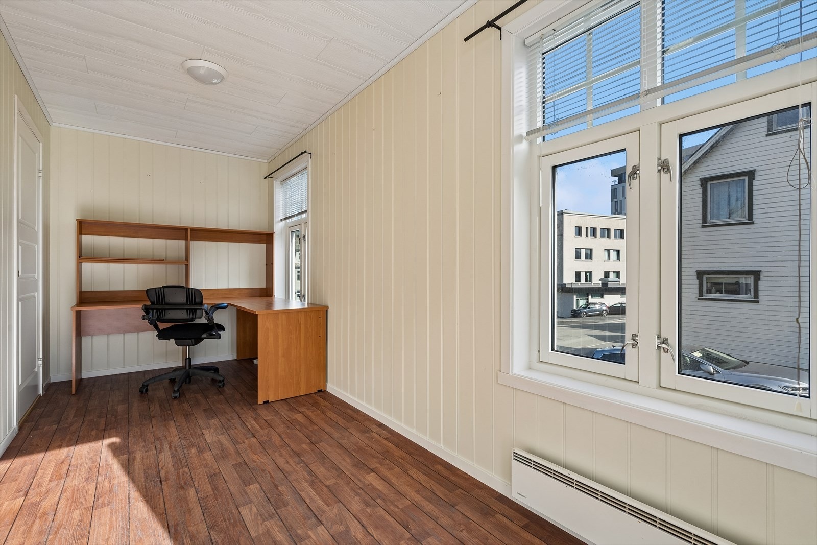 Kontorrommet har malte panelvegger og laminatgulv som gir et praktisk og funksjonelt arbeidsområde. Galleribilde