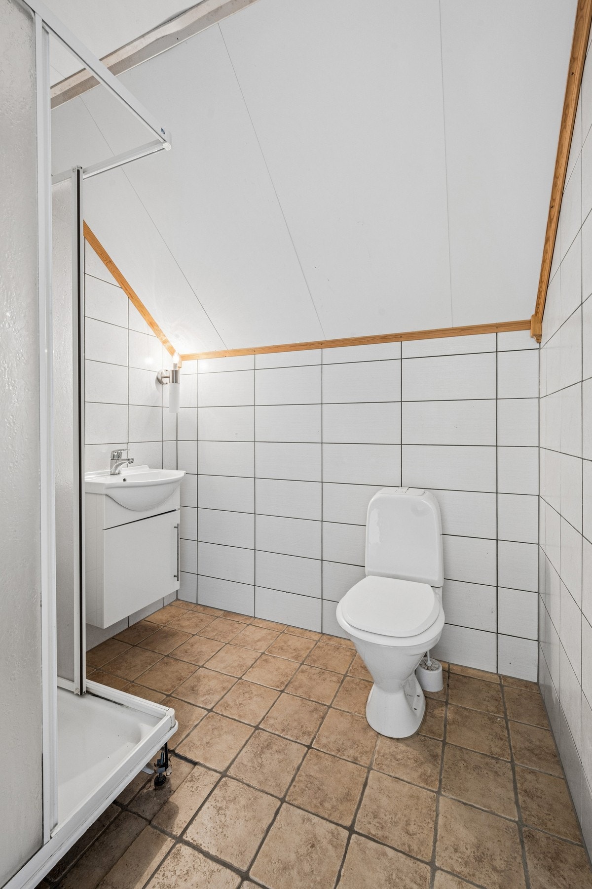 Badet i loftsetasjen har fliser på gulv og vegger, og er utstyrt med dusjkabinett. Galleribilde
