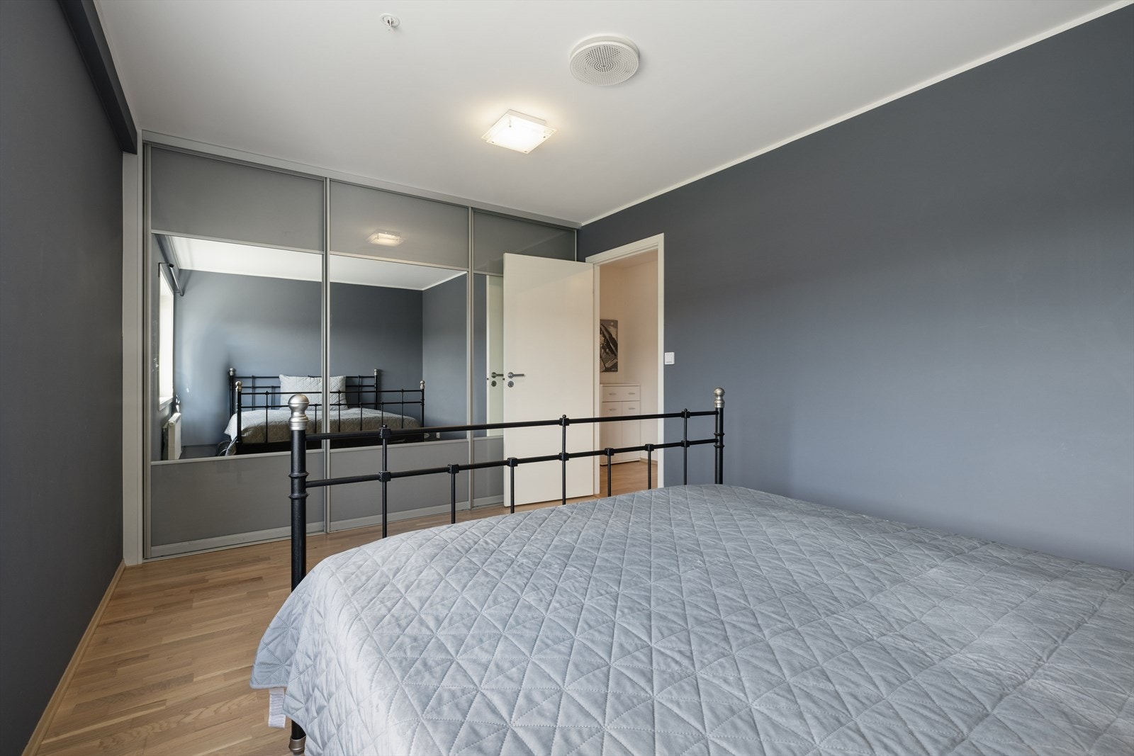 En stor skyvedørsgarderobe med speilfronter gir rikelig med oppbevaringsplass. Galleribilde