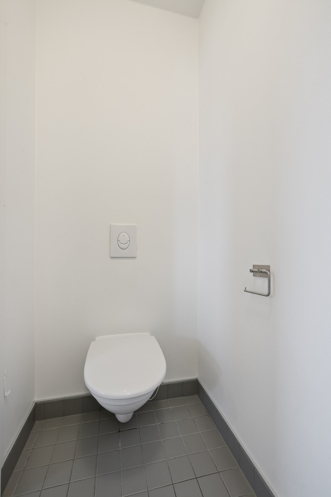 Praktisk, separat toalettrom med flislagt gulv, veggmontert wc og servant. Galleribilde
