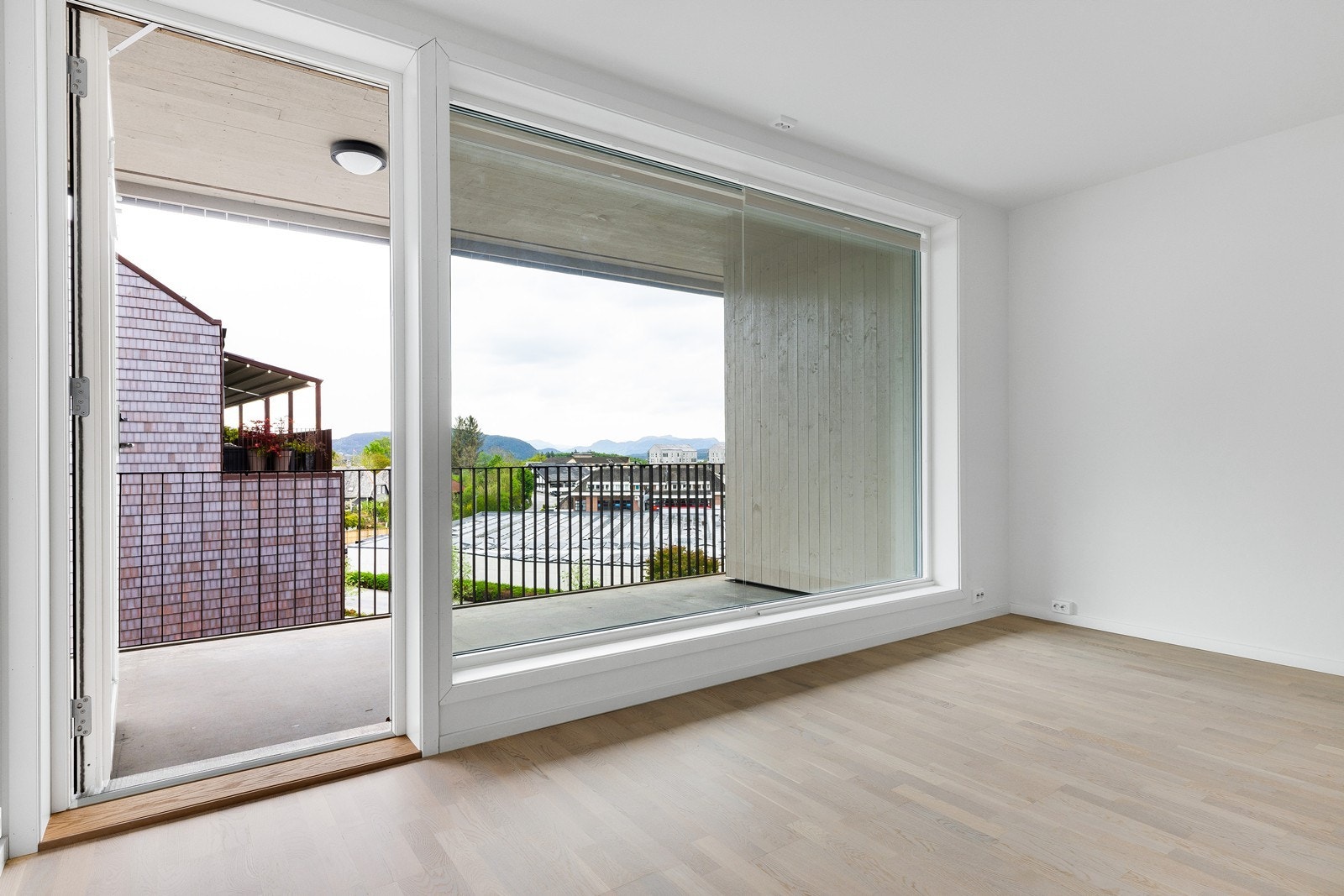 Balkongen har et praktisk overbygg og man sitter skjermet og fint med et yrende sentrum utenfor. Galleribilde