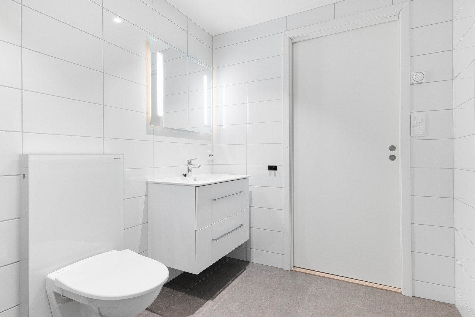 Badet har servant med skuffer under, speil med integrert belysning og tidløse materialvalg. Galleribilde
