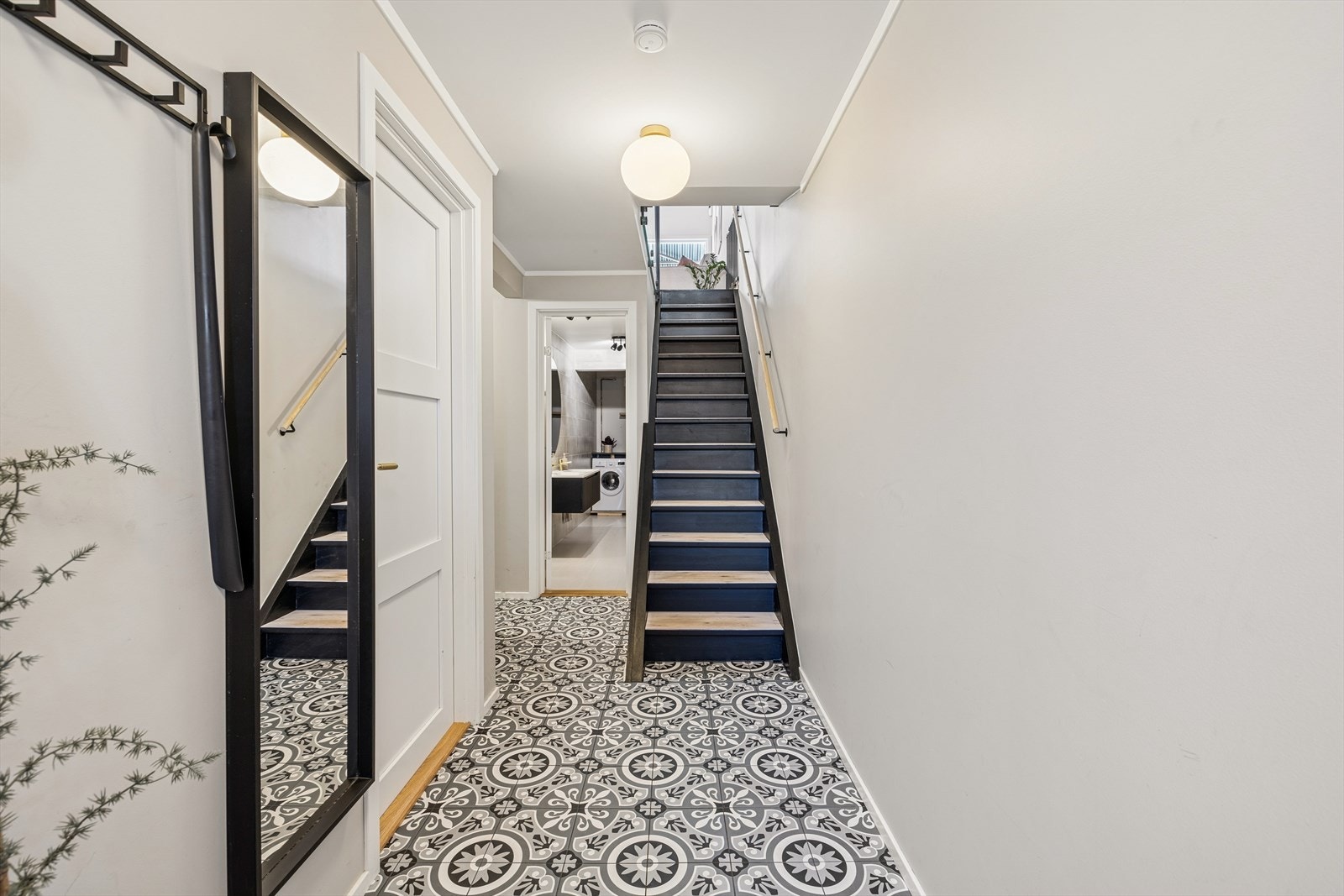 Fra gangen leder en malt, lukket tretrapp med glassvegger opp til andre etasje. Galleribilde