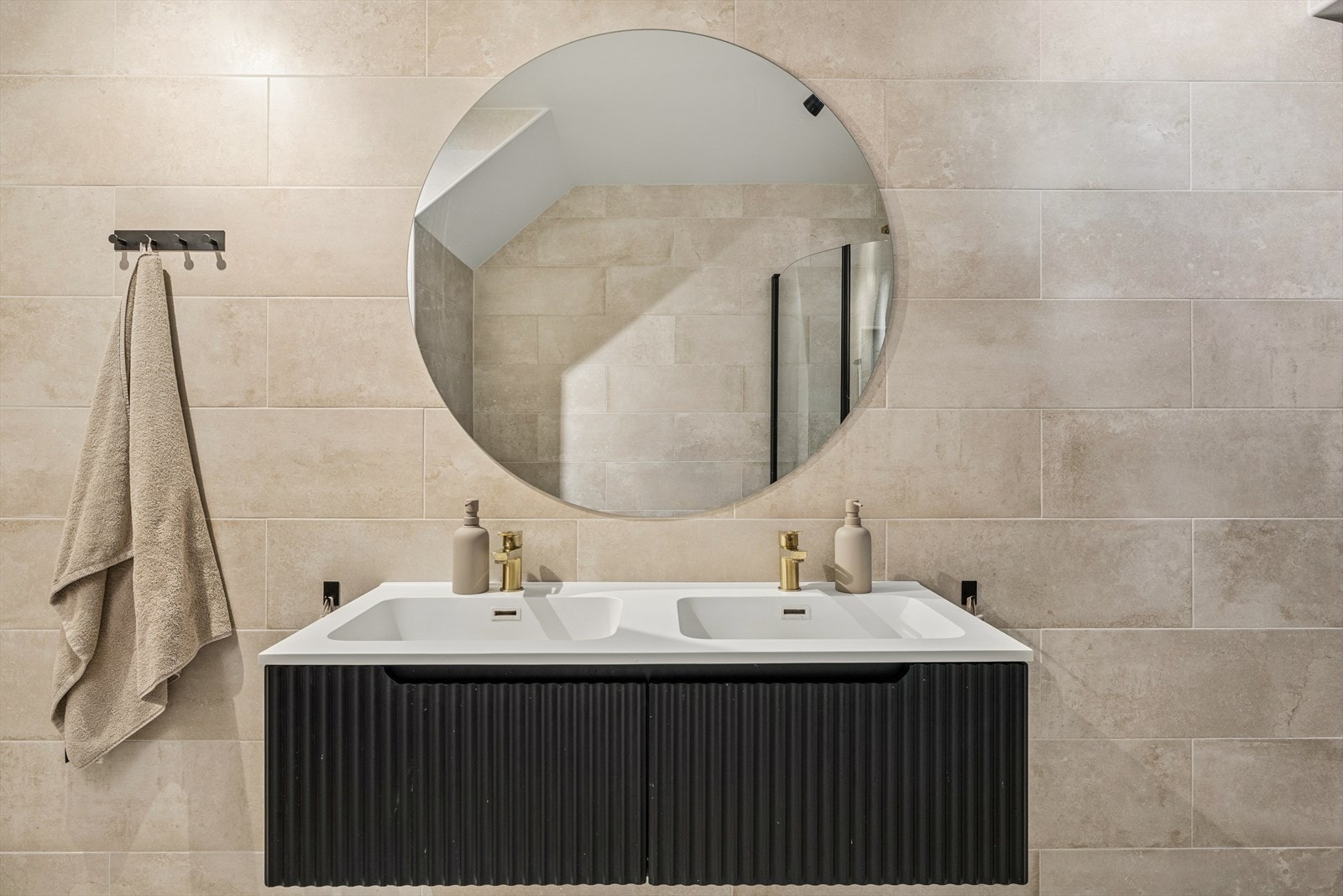 Badet er utstyrt med vegghengt toalett, dusjhjørne med glassdører, innredning med heldekkende benkeplate og dobbel servant, samt opplegg for vaskemaskin. Galleribilde