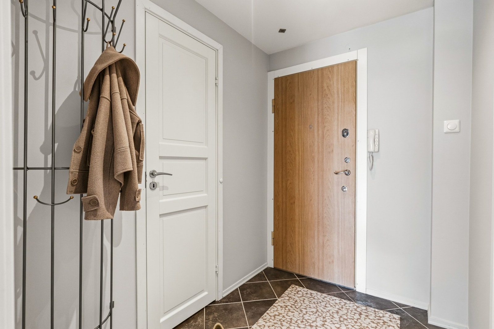 Velkommen hjem! Entreen har flislagt gulv. Veggene ble helsparklet og malt i fargen Elegang Beige mai 2026. Galleribilde