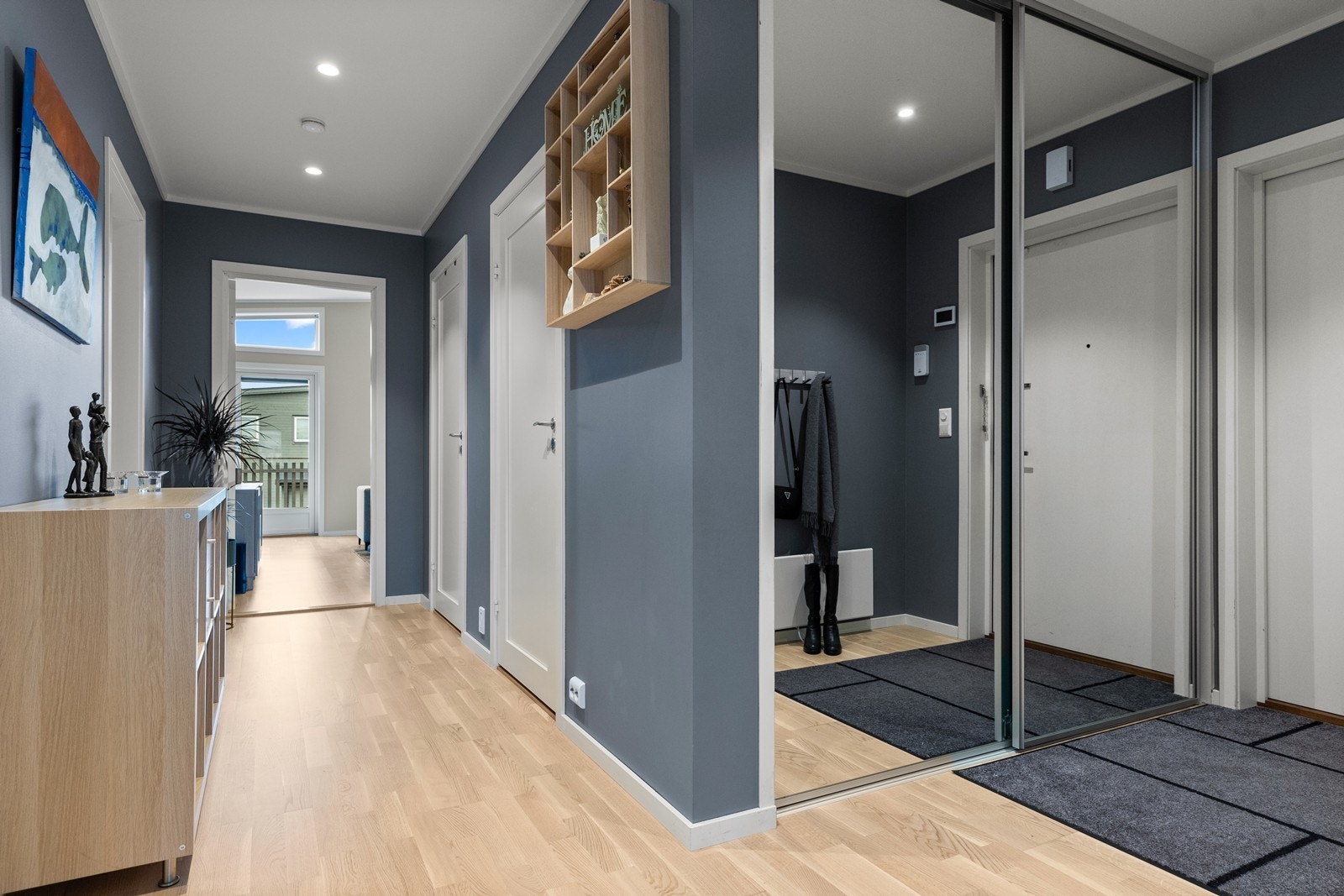 Allerede i gangen møtes du av den lune og moderne utførelsen som er gjennomgående for boligen. Downlights i taket er gjennomgående i de fleste rom. I entréen er det dessuten integrert skyvedørsgarderobe med speilfronter Galleribilde