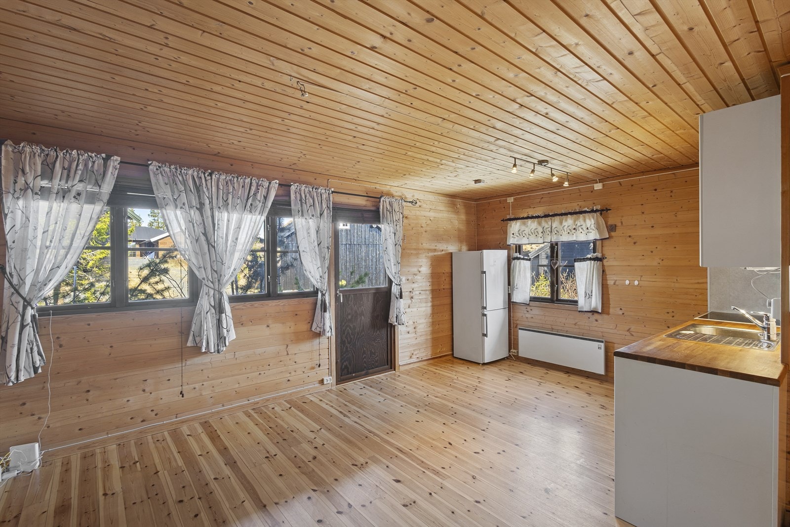 Gjennomgående bruk av treverk på gulv, vegger og i himling skaper en helhetlig og klassisk hyttestil. Galleribilde