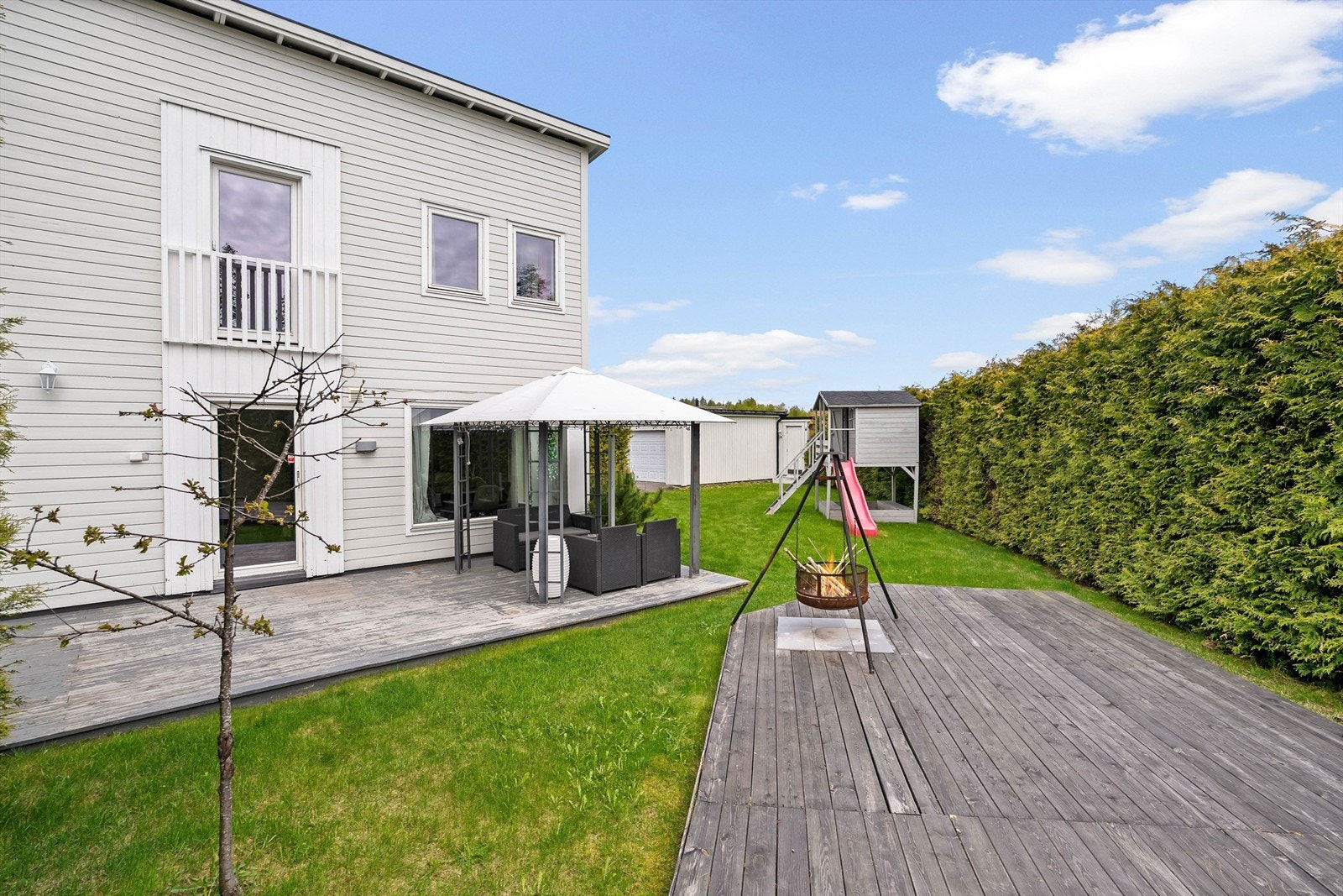 Eiendommen har flott terrasse og platting på baksiden av boligen samt usjenert og romslig hage! Galleribilde