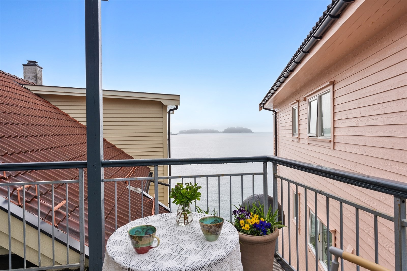 Fra balkongen er det et glimt av sjøen mellom bygningene. Galleribilde
