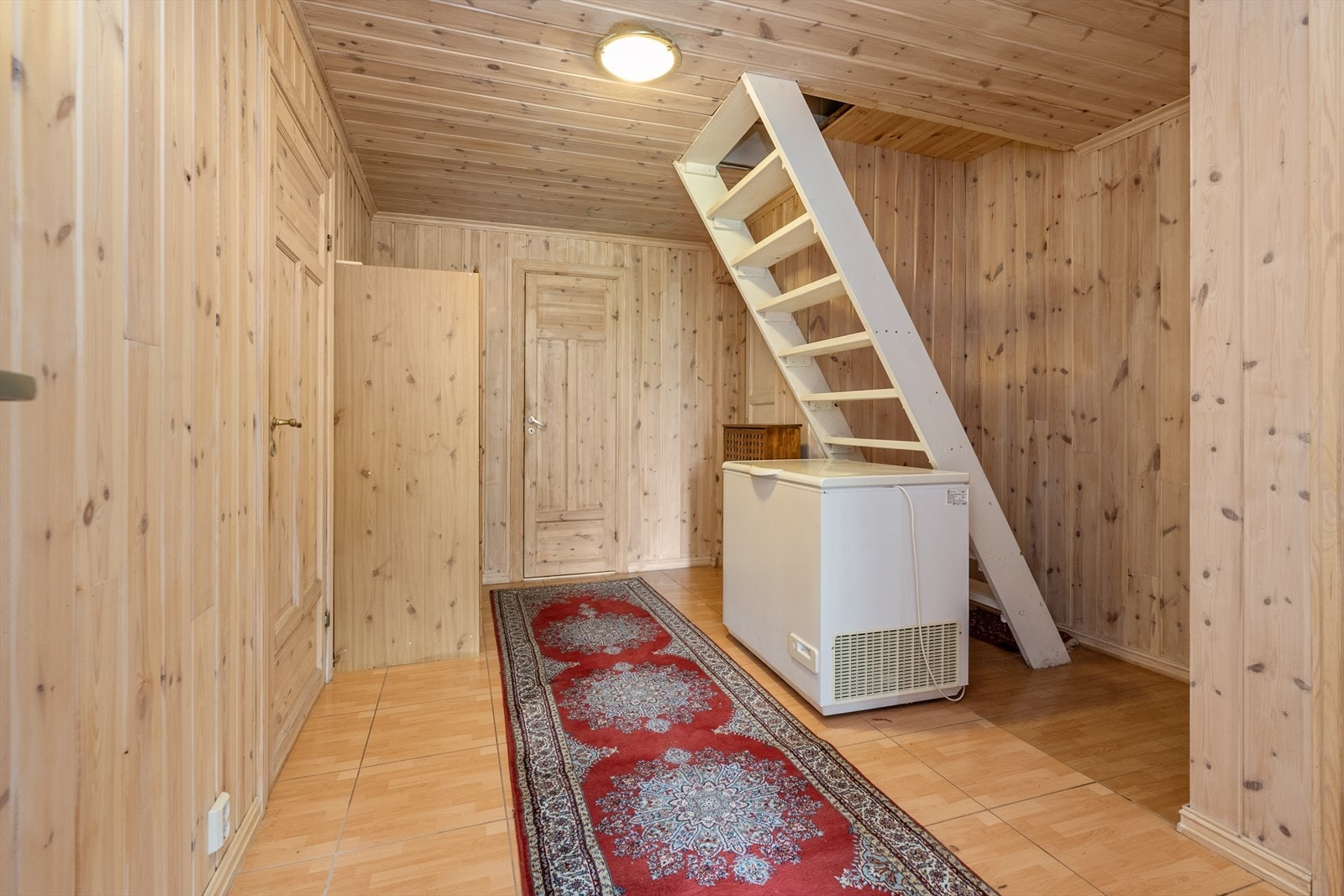 Gang i underetasjen som binder rommene sammen og har trapp opp til første etasje. Trappen er flyttet og endret uten søknad og godkjenning hos kommunen. Galleribilde