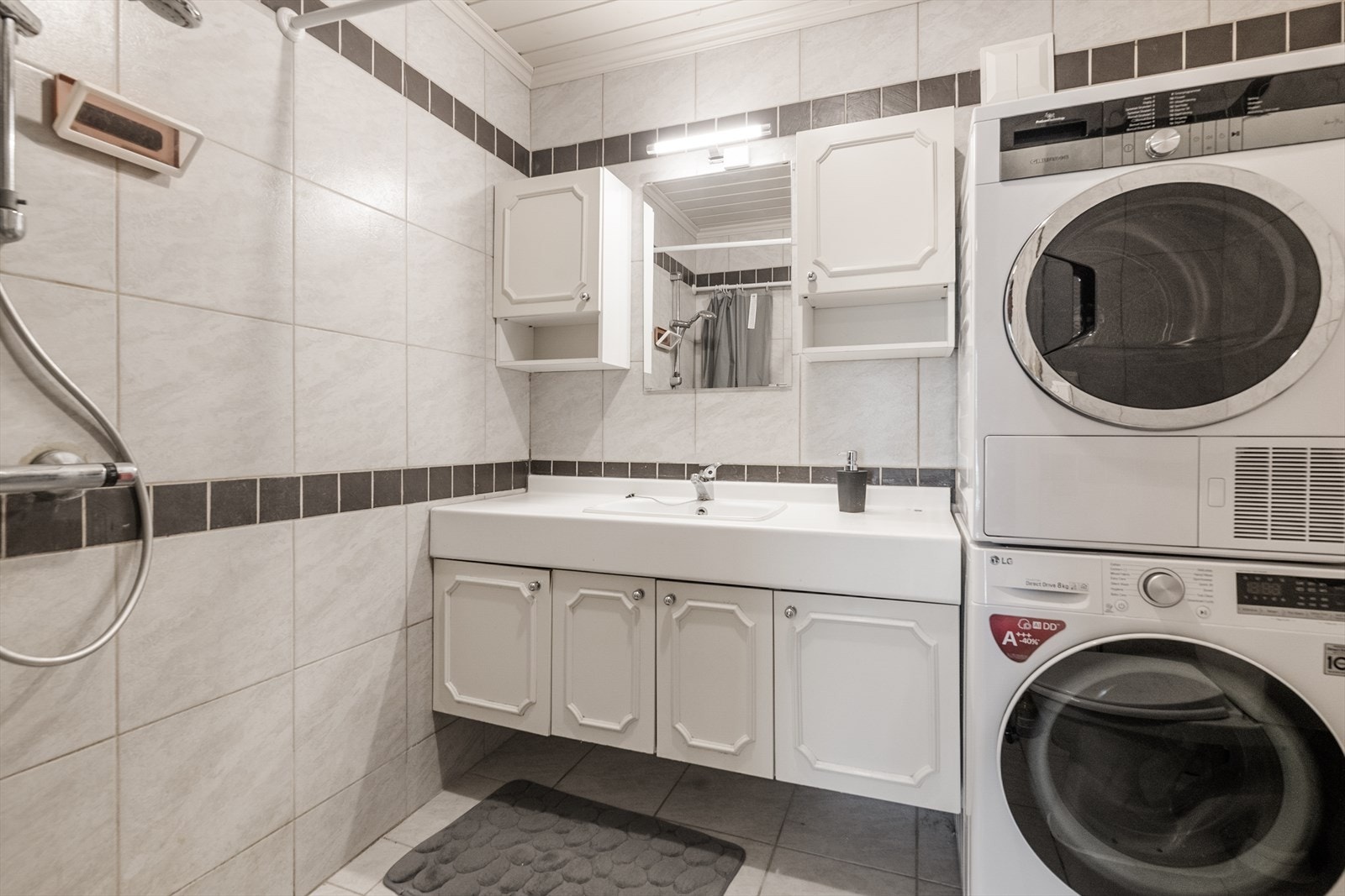 Badet i underetasjen er flislagt, har varmekabler og er utstyrt med dusjhjørne og opplegg for vaskemaskin. Galleribilde